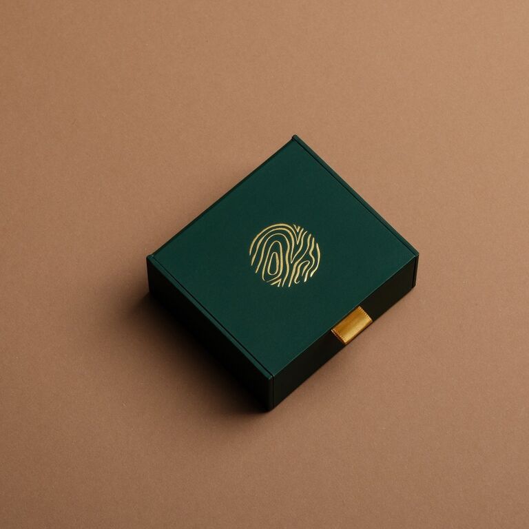 "Geschenkbox Ringen": Elegante groene geschenkdoos met gouden details en strak design.