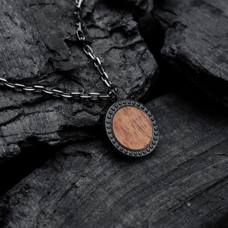 "Collar Interplay", un elegante collar con madera de koa y detalles grises en una cadena texturizada.