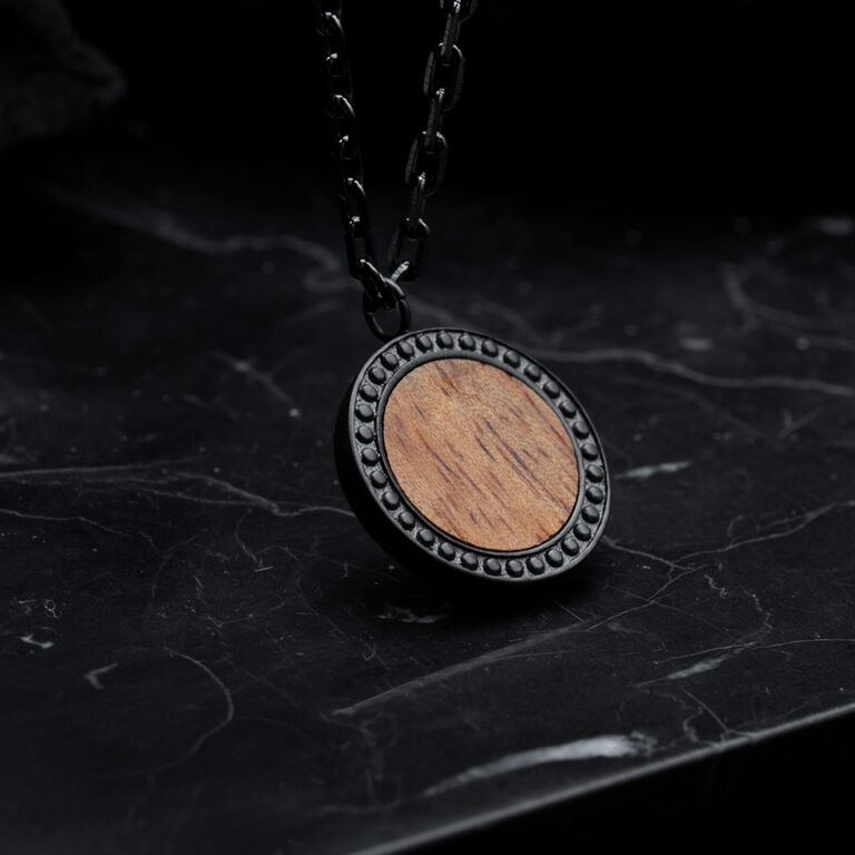 Collar "Collar Interplay" con dise&ntilde;o en madera de koa y gris, sobre una elegante cadena.