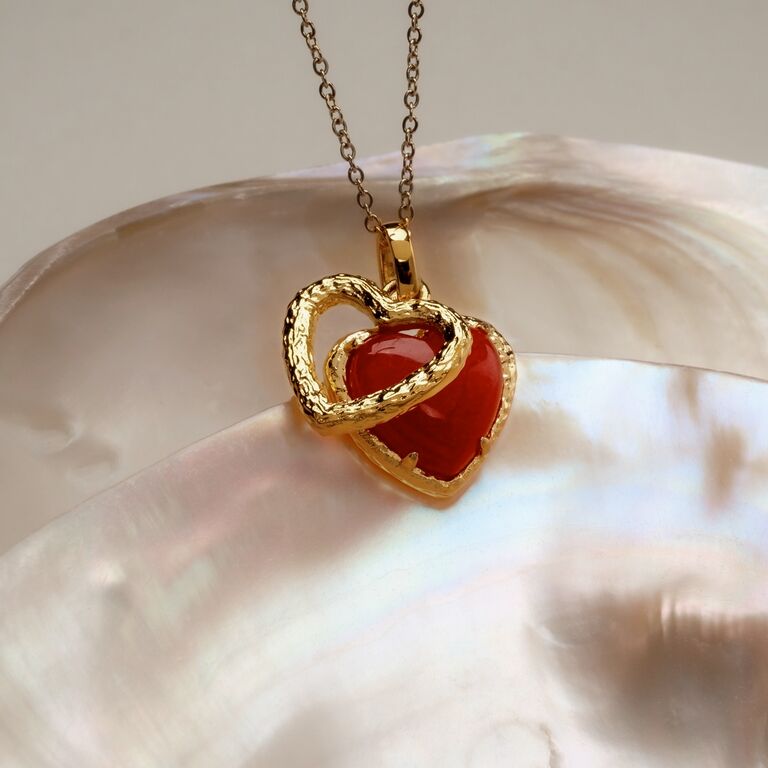 Collier "Collier Amorance" pr&eacute;sentant un design en forme de c&oelig;ur avec une pierre de calc&eacute;doine et d'&eacute;l&eacute;gants accents dor&eacute;s.