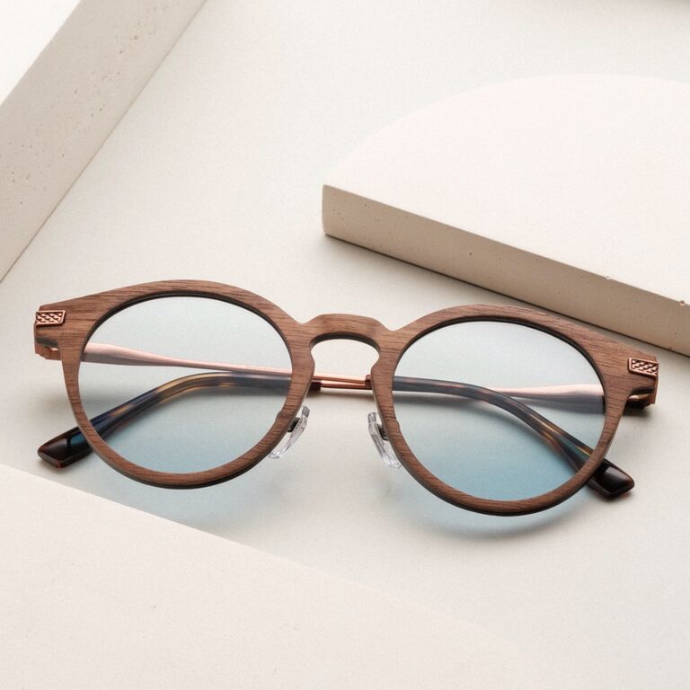 "The Maverick" zonnebril met een houten notenhouten montuur en bronzen accenten, met een stijlvol, minimalistisch design.